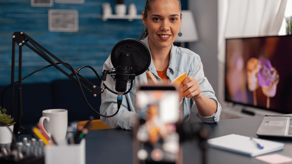 Women with a book in her hands doing a social media live, engaging her community, Engaging your audience