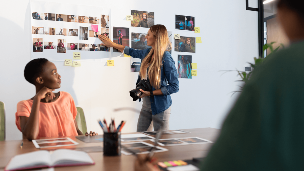 Three people looking at pictures and planning on a wall, social media planning and content creation, Brand Identity, Website Design & Development